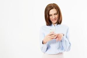 mujer escribiendo un mensaje de texto en un teléfono inteligente. imagen de mujer joven de pie sobre fondo blanco mediante teléfono móvil. foto