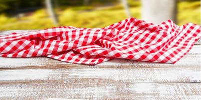 checkered red tablecloth on an empty table - top view photo