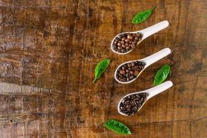 A collage of coffee beans in spoon showing various stages  through to roast photo