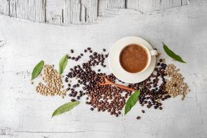 coffee cup and coffee beans on white wooden background photo