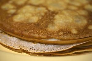 Delicious homemade pancakes on milk close-up in the kitchen photo