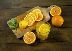 Preparation of orange juice. A glass of juice surrounded by oranges. photo