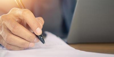 Closeup hand write on paperwork , Hand hold pen sign document photo