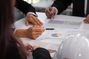 Closeup hand holding pen point on graph chart in document meeting business photo