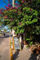 Empty chairs and tables at open air restaurant with signboard photo