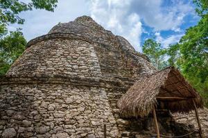 Pirámide de Nohoch Mul y templo con techo de paja en las ruinas mayas de Coba.