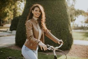 mujer joven montando bicicleta en el día de otoño foto