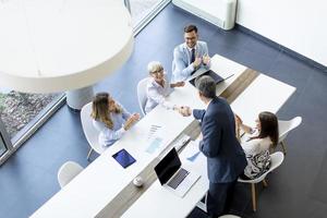 Vista aérea en un grupo de gente de negocios trabajando juntos y preparando un nuevo proyecto en una reunión en la oficina. foto