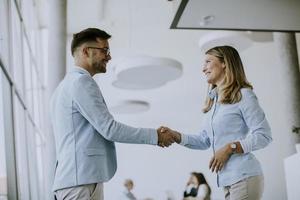 Young business couple handshaking in the office photo