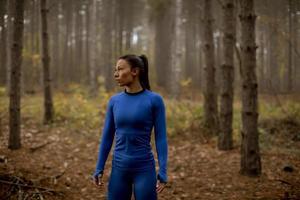 Young woman take a break during outdoor exercise on the forest trail at autumn photo