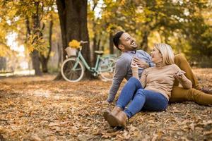 pareja joven, sentado, en, suelo, en, otoño, parque foto