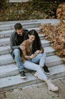 pareja joven, sentado, en, exterior, escaleras, en, un, día de otoño foto