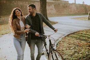 pareja joven, ambulante, con, bicicleta, en, otoño, parque