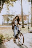 mujer joven montando bicicleta en el día de otoño foto
