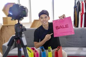 asian man blogger present and review product video broadcast live stream video to a social network. blogging, vlogging, online shopping, and social media concept photo