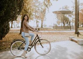 mujer joven montando bicicleta en el día de otoño foto