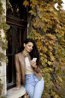 Young woman with mobile phone on autumn day photo