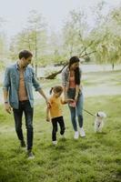 Happy family with cute bichon dog in the park photo