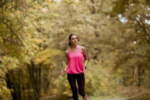 Healthy fitness woman training for marathon outdoors in alleyway photo