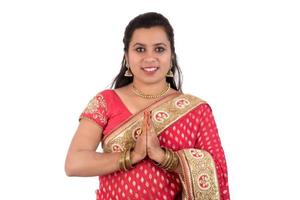 Beautiful Indian girl in a tradition sari with welcome expression inviting, greeting Namaste photo