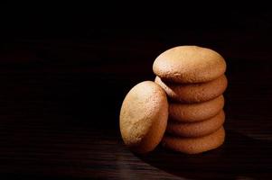 BISCUITS - Stack of delicious cream biscuits filled with chocolate cream on black background photo