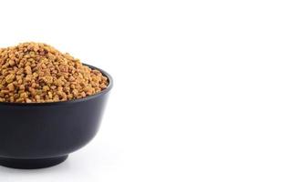 Fenugreek seeds in bowl isolated on white background photo