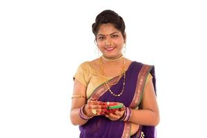 Portrait of a Indian Traditional Girl holding diya, Diwali or deepavali photo with female hands holding oil lamp during festival of light on white background