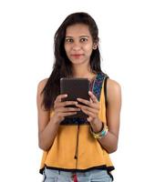 Retrato de una niña feliz mediante teléfono móvil aislado sobre fondo blanco. foto