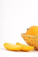 Mango fruit in basket with slice on white background photo