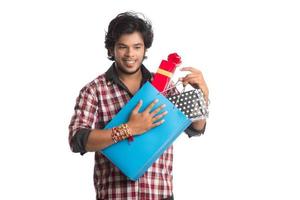 Young men showing rakhi on his hand with shopping bags and gift box on the occasion of Raksha Bandhan festival. photo