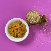 Sesame Seeds in clay pot with Jaggery in bowl on pink background photo