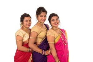 Hermosas niñas indias tradicionales en sari posando sobre fondo blanco. foto