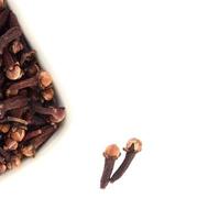 Cloves in plate isolated on white background photo