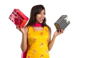 Portrait of young happy smiling Indian Girl holding gift boxes on a white background. photo