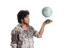 young man with a world globe on a white background. photo