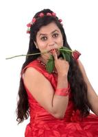 Beautiful young girl or woman holding and posing with red rose flower on white background photo