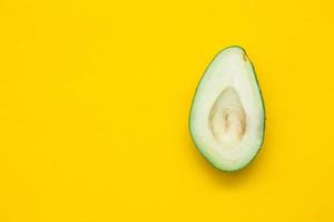 Halve of avocado on a yellow background photo
