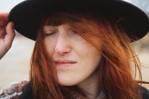 Portrait of a beautiful woman with her eyes closed in a hat photo