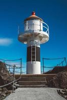 faro en el muelle en el fondo de las montañas y el cielo azul en las islas lofoten. lugar para texto o publicidad foto