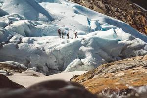Private group of hiker walking on glacier. Glacier group of people hiking mountains photo