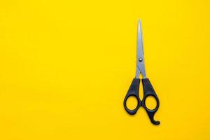 Black scissors on a yellow background photo