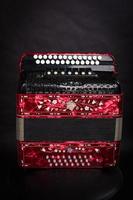 Russian folk instruments.Red bayan on a black background.Russian accordion photo
