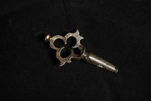 llave de oro sobre fondo negro. llave de cerradura de cobre vintage foto