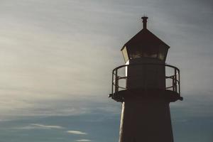 Lighthouse in silhouette at sunset and dramatic sky. Place for text or advertising photo