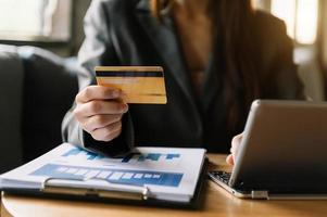 Manos de mujer de negocios usando un teléfono inteligente y sosteniendo una tarjeta de crédito con un diagrama de efecto de capa digital como compras en línea