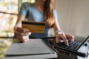 Close up of Hand using credit card and smartphone, laptop computer on wooden desk with photo