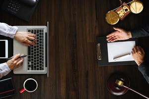 Top view Business and lawyers discussing contract papers with brass scale on desk in office. Law, legal services, advice, justice photo