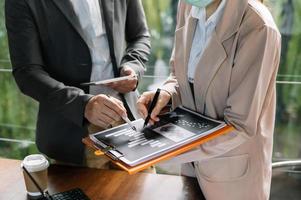 Dos inversores profesionales de reuniones de negocios que trabajan junto con teléfonos inteligentes y computadoras portátiles y digitales foto