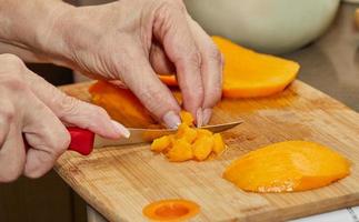 el cocinero corta el mango jugoso en rodajas para hacer ensalada foto