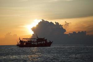 tourist boat cruising against beautiful sunset sky photo